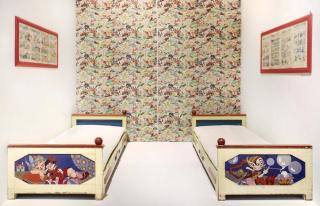 Camera Antonio Rubino. Camera composta da due letti con testate dipinte e firmate, così come le tende in fondo la cui fantasia è stata disegnata dall’artista.