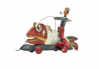 Pinocchio che cavalca il pescecane. Personaggio raffigurante un Pinocchio “lupo di mare”, dai piedi pinnati, che cavalca il famelico Pesce-cane, che apre e chiude la bocca quando viene trainato. "Una orribile testa di mostro marino, con la bocca spalancata, come una voragine, e tre filari di zanne che avrebbero fatto paura anche a vederle dipinte. E sapete chi era quel mostro marino? Quel mostro marino era né più né meno quel gigantesco Pescecane, (…) che per le sue stragi e per la sua insaziabile voracità