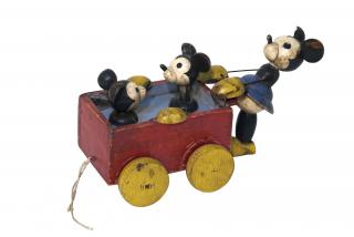 Minnie, Tip e Tap. Gioco da traino raffigurante Minnie che spinge una carrozzina con dentro Tip e Tap, i due topolini alzano e abbassano le teste quando il gioco viene tirato.