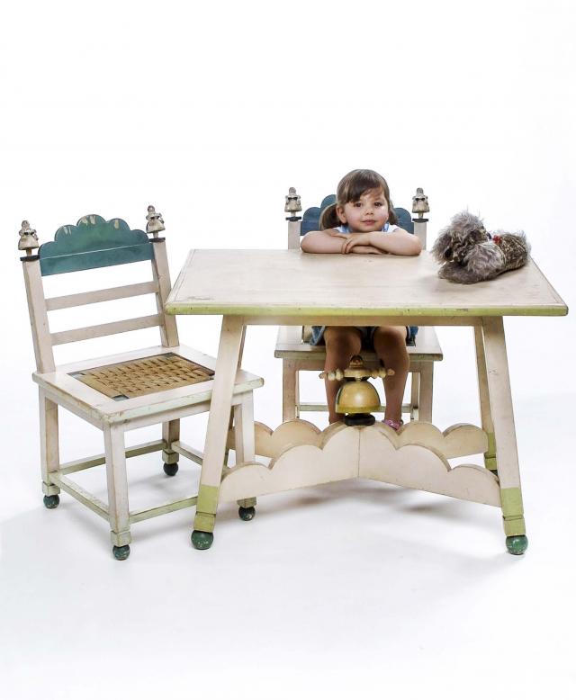 Sedie e tavolo Lenci-Mario Sturani. Sedie e tavolino decorati da un motivo ondulato e personaggi scolpiti a tutto tondo, sedie dalla seduta impagliata.