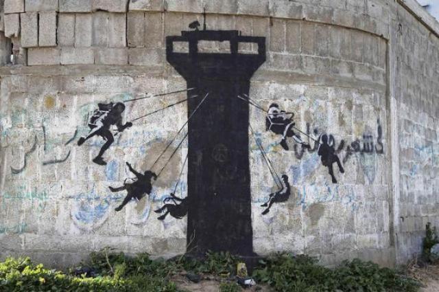 Children using an Israeli army watch tower as a swing ride