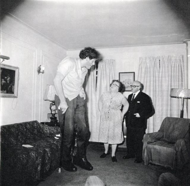 Un gigante ebreo con i suoi genitori nella loro casa del Bronx, N.Y.