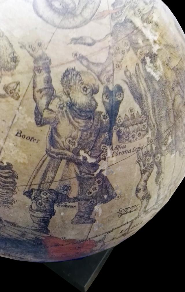 Particolare del globo celeste inv. MV 70155: la costellazione boreale del Boote (il guardiano dei buoi), raffigurato come un uomo vestito con pesanti indumenti, cappuccio e stivaloni di pelle e pelliccia, con un grosso bastone in mano. Visto di spalle, l'uomo ha il volto rivolto verso la costellazione dell'Orsa Maggiore. 